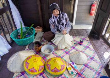 AMINAH Naim menunjukkan cara menganyam topi mengkuang ketika ditemui dalam program Media Fam Trip Tourism Selangor bersama Media Mulia Sdn. Bhd. dekat Nazbell Cottage & Garden, Sungai Panjang, Sabak Bernam, Selangor. – UTUSAN/SHIDDIEQIIN ZON