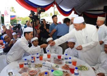 AHMAD Zahid Hamidi (kanan) menyantuni pelajar tahfiz di Majlis Santunan Kasih Ramadan di Pusat Transformasi Ilmu Bukit Tiu, Machang, Kelantan.-UTUSAN/KAMARUL BISMI KAMARUZAMAN