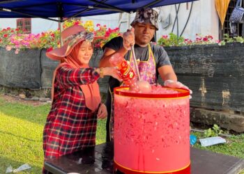 MOHAMAD Zainuri Zin (kanan) bersama isteri menyiapkan bancuhan air untuk diagihakn secara percuma kepada penduduk di Kampung Gual Sitok, Rantau Panjang, Kelantan.