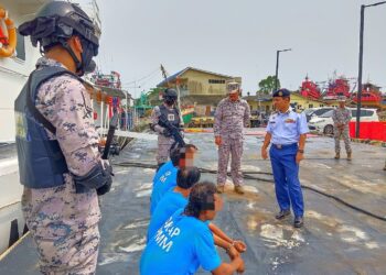 SYED Nor Adli Syed Ab. Rahman (kanan) memeriksa empat nelayan Vietnam yang ditahan selepas sidang media di Jeti Maritim Malaysia Kelantan, Tok Bali, Pasir Puteh, Kelantan-UTUSAN/YATIMIN ABDULLAH