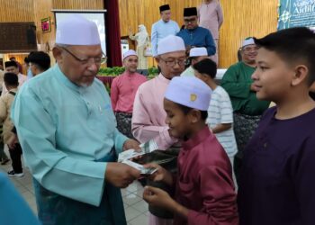 AHMAD Yakob (kiri) menyampaikan duit raya kepada anak-anak Kelantan di perantauan yang diraikan pada Majlis Mesra Aidilfitri Pimpinan Kerajaan Negeri Bersama Anak Kelantan di Perantauan di Balai Islam Lundang, Kota Bharu, Kelantan malam tadi. UTUSAN/MUSTAQIM MOHAMED