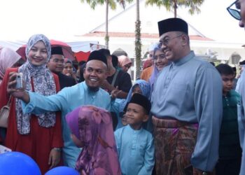 MUHAMMAD Sanusi Md. Nor bergambar bersama orang ramai yang hadir pada Majlis Rumah Terbuka Aidilfitri Menteri Besar di Seri Mentaloon, Alor Setar.