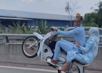 AKSI pasangan suami isteri melakukan aksi wheelie semasa menaiki motosikal di Jalan Pasir Puteh, Kampung Peringat, Kota Bharu, Kelantan baru-baru ini.-UTUSAN/MEDIA SOSIAL