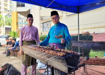 AZMAN Ismail (kanan) menunjukkan kemahiran membakar sate pada Majlis Ramah Mesra KPDN Negeri Kelantan yang berlangsung di Kota Bharu, Kelantan hari ini. UTUSAN/MUSTAQIM MOHAMED