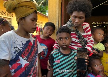 ALANG Kuang (tengah)  menunjukkan contoh gambar harimau yang dipercayai menyerang bapa saudaranya di Hulu Sungai Aring, Gua Musang, Kelantan-UTUSAN/AIMUNI TUAN LAH