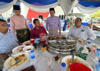 SYED Nur Adli Sye Ab. Rahman (berdiri, dua dari kanan) melayan tetamu hadir sempena Sambutan Aidilfitri Maritim Malaysia Kelantan di Tok Bali, Pasir Puteh, Kelantan, hari ini.-UTUSAN/TOREK SULONG