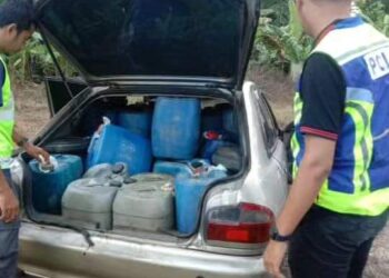 ANGGOTA penguat kuasa KPDN Kelantan memeriksa tong yang mengandungi minyak diesel selepas menahan sebuah kereta di tepi jalan Kampung Teratak Pulai, Bachok, Kelantan. - UTUSAN/IHSAN KPDN KELANTAN