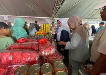 FUZIAH Salleh (tiga dari kanan) meninjau barangan Jualan Rahmah yang dijual di tapak ekspo Pantai Irama, di Bachok, Kelantan, semalam.-UTUSAN/TOREK SULONG