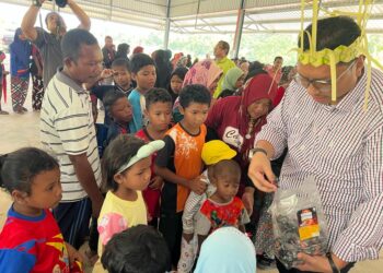 MOHD. Syahbuddin Hashim (kanan) menyantuni  kanak-kanak Orang Asli sempena Program Kita Madani di Pos Tuel, Gua Musang, Kelantan, semalam.UTUSAN/AIMUNI TUAN LAH