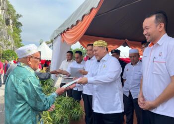 MOHD. Amar Nik Abdullah (dua dari kanan) menyerahkan geran hak milik tanah kepada penduduk di Felda Chiku 2, Gua Musang, Kelantan hari ini.UTUSAN/AIMUNI TUAN LAH