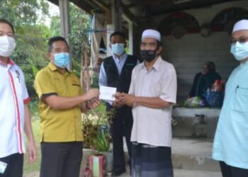 AB. Pattah Hasbullah (dua dari kiri) menyampaikan bantuan kewangan disaksikan Mahadi Awang (belakang) kepada Zulkifli di Kampung Merkang, Pasir Puteh, hari ini. - FOTO/TOREK SULONG