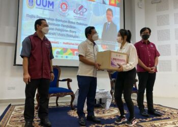 MOHD. Nazir Sudin (dua dari kiri) menyerahkan bantuan kotak makanan kepada pelajar pada Majlis Penyerahan Bantuan Bakul Makanan dan Bantuan Pendidikan YPM di UUM, Sintok, Kedah, hari ini. - FOTO/NUR ANATI JUHARI