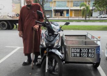 MOHAMED Yusly Mohamed Yusof bersama motosikal roda tiga yang diterimanya daripada Perbadanan Baitulmal Majlis Agama Islam Negeri Sembilan. – UTUSAN/BADRUL HAFIZAN MAT ISA