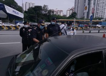 MOHD. Zaki Ismail memeriksa dokumen perjalanan pemandu kenderaan bagi memastikan mereka mematuhi SOP PKP ketika sekatan jalan raya di Plaza Tol Jalan Duta, Kuala Lumpur, hari ini.