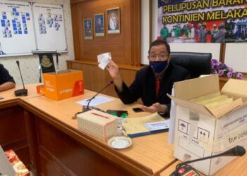 ZULKIFLEE Rashid meneliti barang-barang kes membabitkan kertas siasatan sejak tahun 1995 untuk dilupuskan. - FOTO/DIYANATUL ATIQAH ZAKARYA