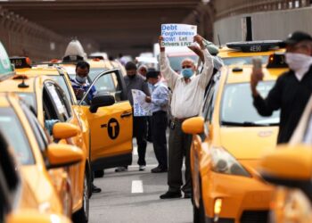 SEKUMPULAN pemandu teksi memegang plakad yang menggesa golongan itu diberi pengecualian hutang kerana pandemik Covid-19 menjejaskan pendapatan mereka di New York, Amerika Syarikat. - AFP