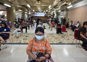 PARA peniaga menunggu giliran untuk menerima suntikan vaksin Covid-19 di pasar Tanah Abang di Jakarta, Indonesia. - AFP