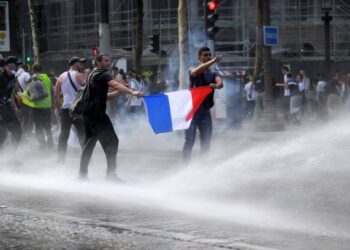 PASUKAN keselamatan melepaskan meriam air kepada penunjuk perasaan di Paris, Perancis. - AFP