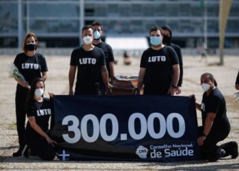 KUMPULAN petugas kesihatan profesional memegang kain rentang yang menunjukkan jumlah korban akibat Covid-19 dalam satu protes di Brasilia, Brazil. - AFP