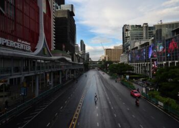 SEORANG penduduk melintas jalan di persimpangan Ratchaprasong di Bangkok ketika perintah berkurung dilaksanakan pada 12 Julai lalu. - AFP