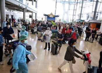 PELANCONG antarabangsa menunggu arahan daripada petugas lapangan terbang selepas tiba di Bangkok, Thailand. - AFP