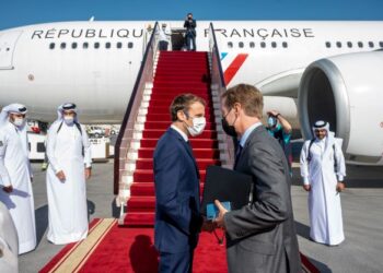 EMMANUEL Macron berbual dengan Duta Perancis di Qatar, Jean-Baptiste Faivre sebelum berlepas ke Arab Saudi. - AFP