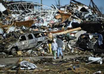 DUA penduduk melihat kemusnahan yang berlaku akibat tornado di Mayfield, Kentucky. - AFP