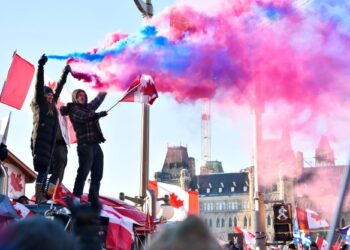 PENUNJUK perasaan menyalakan suar ketika menyertai protes membantah mandat vaksin Covid-19 di Ottawa, Kanada. - AFP