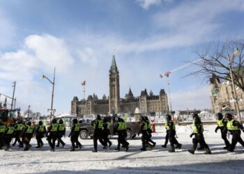 ANGGOTA polis berjalan melepasi bangunan Parlimen Kanada selepas penunjuk perasaan yang protes di kawasan itu disuraikan di Ottawa, Ontario, Kanada. - AFP