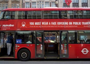 PERINGATAN mengenai pemakaian pelitup muka pada dinding bas awam di London. - AFP