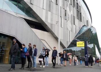 ORANG ramai beratur di luar stadium bagi menerima suntikan vaksin di London. - AFP