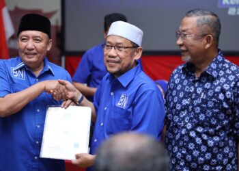 AHMAD Jazlan Yaakub (kiri) menyerahkan watikah kepada Ceh Abdullah Mat Nawi sebagai calon BN Parlimen Tumpat di Bangunan UMNO negeri, Kota Bharu, Kelantan hari ini. - UTUSAN/KAMARUL HISMI KAMARUZAMAN