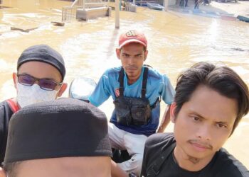 AZWAN Omar (belakang) ketika dalam misinya pada Jumaat lalu membantu mangsa terjejas banjir di Temerloh, Pahang.