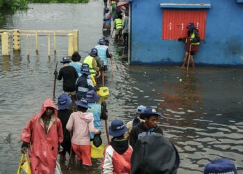 ORANG ramai berjalan melalui air banjir selepas beberapa rumah terjejas akibat hujan lebat di kawasan kejiranan Antananarivo, Madagascar.-AFP