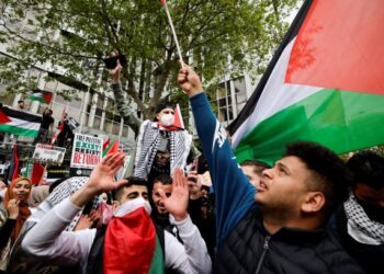 AKTIVIS Pro Palestin mengibarkan bendera semasa demonstrasi di luar bangunan Kedutaan Israel di London. -AFP