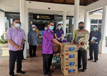 AHMAD Razif Abdul Rahman (depan, kanan) menyerahkan bantuan barangan makanan untuk warga sekolah  yang ditempatkan di pusat kuarantin Marang kepada Tun Ahmad Faisal Tun Abdul Razak, hari ini.