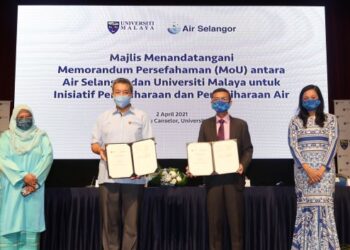 MOHD. Hamidi Abd. Shukor (dua, kanan) dan Suhaimi Kamaralzaman (dua, kiri) menunjukkan dokumen memorandum persefahaman antara Universiti Malaya dan Air Selangor yang ditandatangani di Kuala Lumpur, baru-baru ini.