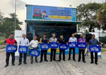 AZAHARI Zainal Abidin (tengah) memegang beg guna semula bersama wakil penduduk, penguatkuasa PPj dan pekerja Alam Flora di hadapan 3R on Wheels (3ROW) Putrajaya.