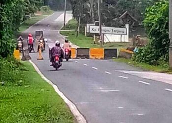 PENDUDUK menaiki mptosikal merentasi halangan selepas penghadang konkrit dialihkan individu tidak bertanggungjawab di  Jalan Bangau Tanjung di Temerloh, Pahang.