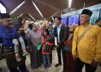 AMIRULHUSNI Sahar (kanan) bersama isteri, Siti Nur Aminah Khatijah, 36 (tengah) dan anaknya, Nur Adelea dan Noura Misron, 4, (dua kanan) disambut ahli keluarganya ketika tiba di KLIA. - UTUSAN/FAISOL MUSTAFA