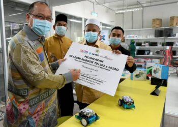 AHMAD Amzad Hashim (kiri) menandatangani plak pelancaran Akademi Robotik TD 1303 x Jazro di TD1303 di Kuala Terengganu, Terengganu, hari ini.