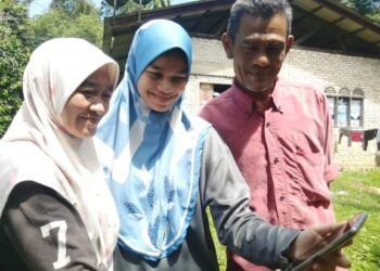 NUR Amalia Aqilah Mohd. Basri (tengah) berkongsi kegembiraan mendapat keputusan cemerlang 9A dalam dalam Sijil Pelajaran Malaysia (SPM) 2020 bersama ibu bapanya di Kampung Binjai Kertas di Hulu Terengganu baru-baru ini. – Mingguan/NOOR HAYATI MAMAT