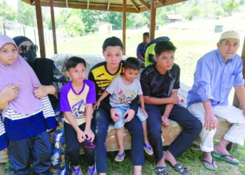 WAN Zaini Wan Abdullah (dua dari kiri) dan suaminya, Aziz Mustafa (kanan) bersama lima daripada tujuh anak Allahyarham Rubiah Sabtu di Tanah Perkuburan Islam Bandar Bukit Besi, Dungun, semalam.