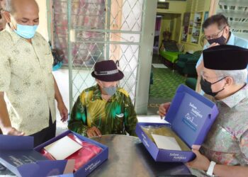 ANNUAR Musa (kanan) menyampaikan sepersalinan baju Melayu ketika menziarah Seniman Mat Sentol di kediamannya di Jalan Rajawali, Larkin, Johor Bahru hari ini. -UTUSAN/KHAIRUL MOHD ALI