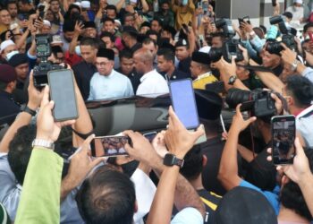 ANWAR Ibrahim bersalam dengan jemaah selepas menunaikan solat Jumaat di Masjid Muhammad Al-Fateh di Taman Jati, Meru di Ipoh, Perak. - UTUSAN