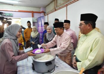 MOHAMMAD Yusof Apdal (tengah) menyenduk nasi ke pinggan salah seorang mahasiswa ketika melawat UiTM kampus Kota Kinabalu, Sabah.