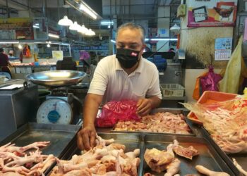 PENIAGA, Shahran Osman, 54, mengasingkan bahagian ayam yang dijualnya di Pasar Awam Larkin, Johor Bahru, Johor. - UTUSAN/ MOHAMAD FAIZAL HASHIM