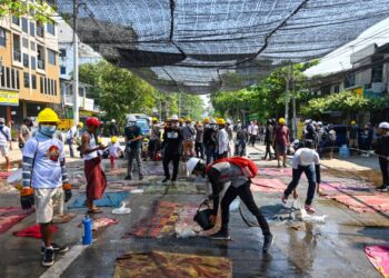 PENUNJUK perasaan membasahkan kain yang akan digunakan untuk mengelak terkena gas pemedih mata di Yangon, Myanmar. - AFP