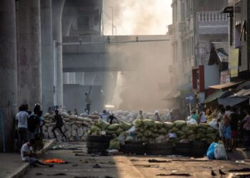 PENUNJUK PERASAAN berdiri berhampiran penghadang ketika menyertai demonstrasi menentang rampasan kuasa tentera di Yangon, Myanmar. - AFP