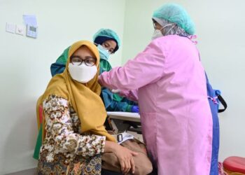 SEORANG wanita menerima suntikan vaksin Covid-19 di hospital di Depok, Jawa Barat, Indonesia. - AFP